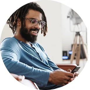 A smiling man using his phone